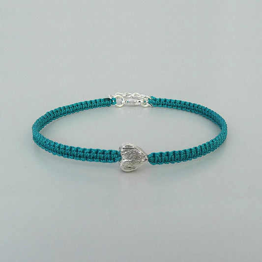 Teal green seven inch macramé bracelet with silver plated textured heart charm, lobster clasp and one inch extender chain.